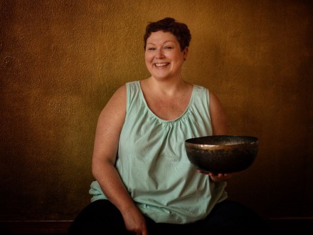 Foto von einer Frau mit einer Klang·schale in der linken Hand. Die Frau lächelt., Bild © Horninger-Jedwabski