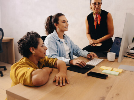 Foto von 3 Personen an einem Schreib·tisch. Die Personen besprechen etwas., Bild © Jacob Lund Photography / stock.adobe