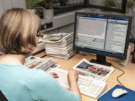 Auf dem Bild sieht man eine Person am Computer. Die Person arbeitet an einer Daten·bank.
