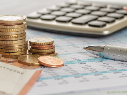 Das Bild zeigt Geld und einen Taschen·rechner.