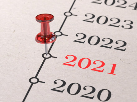 Das Bild zeigt ein Blatt Papier mit den Jahres·zahlen von 2020 bis 2024. Die Zahl 2021 ist rot geschrieben. Bei der Zahl 2021 steckt eine rote Steck·nadel als Markierung.