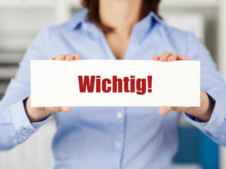 Foto von einer Frau in einer hell·blauen Bluse. Die Frau hält ein Schild in den Händen. Auf dem Schild steht: Wichtig!, Bild © contrastwerkstatt / stock.adobe