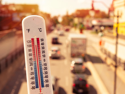 Das Bild zeigt ein Thermometer in einer Stadt.