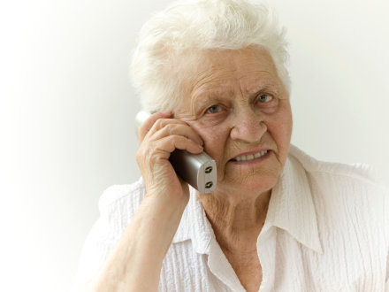 Das Bild zeigt eine ältere Frau beim Telefonieren.