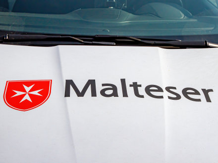 Das Bild zeigt ein Dienst·fahrzeug von den Maltesern mit dem Malteser·kreuz.