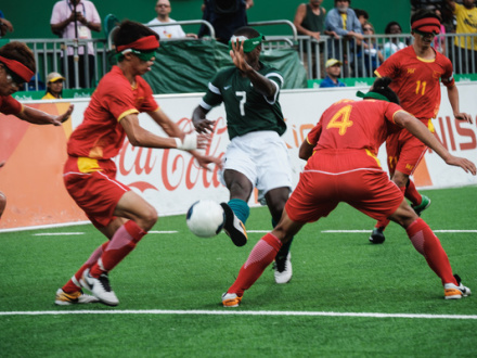 Das Bild zeigt: 5 Männer spielen Blinden-Fußball.