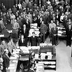 Sekretärinnen und Sekretäre, Ankläger und Verteidiger stehen beim Eintreten der Richter während des Nürnberger "Hauptkriegsverbrecherprozesses".