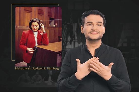 Gebärdensprachübersetzer Rafael Grombelka erläutert für Gehörlose die Geschichte der Nürnberger Prozesse und des Völkerstrafrechtes in der Gegenwart.