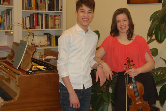 Eine Schülerin und ein Schüler mit Geige und Klavier