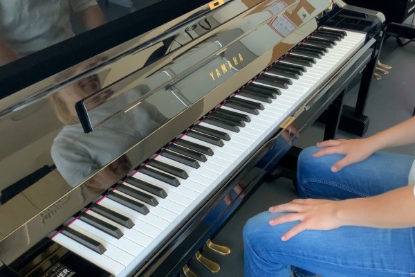 Klaviertastatur von Oben mit Person