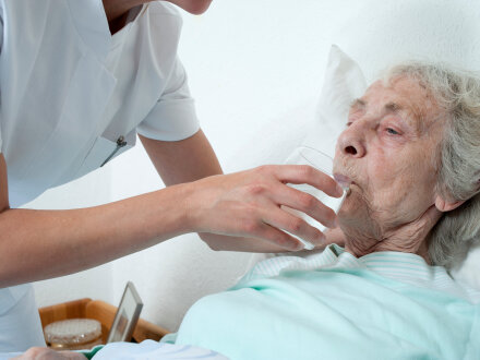 Foto von einer pflege·bedürftigen Frau beim Trinken., Bild © CHW / stock.adobe