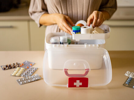 Foto von einer Frau. Die Frau füllt Medikamente in der Haus·apotheke auf., Bild © stock.adobe