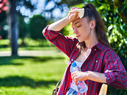 Foto von einer jungen Frau bei Hitze. Der jungen Frau geht es nicht gut., Bild © Goffkein / stock.adobe
