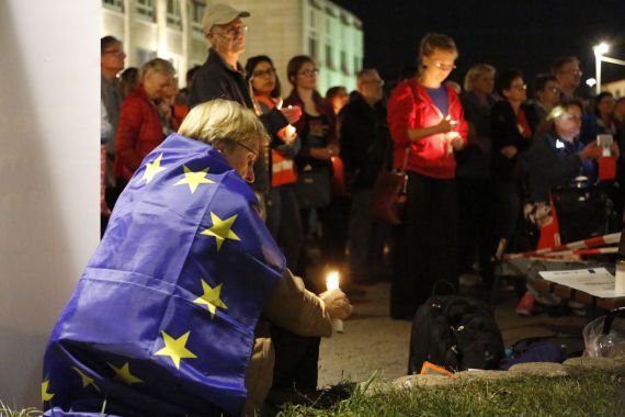 Nürnberg leuchtet für Demokratie - Besucherin mit Europafahne und Kerze