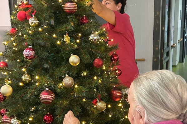 Eine Bewohnerin des Sebastianspitals schmückt den Weihnachtsbaum.