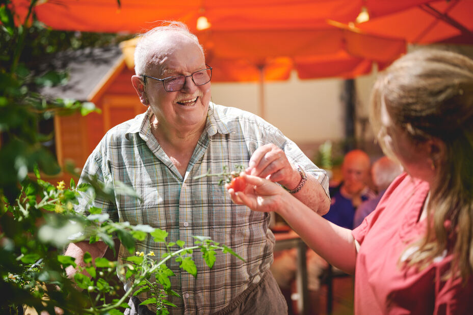 Bild © HARRY BELLACH / NürnbergStift Pflegekraft mit Gast im Garten der Tagespflege, Bild © HARRY BELLACH / NürnbergStift