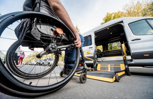 Person im Rollstuhl fährt zum Auto