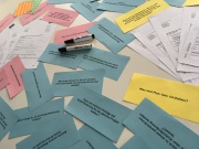 Beschriftete Moderationskarten und Stifte liegen auf einem Tisch
