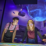 Ein Besucher und eine Besucherin betrachten ein interaktives Exponat im Deutschen Museum