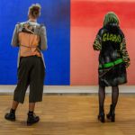 Ein junger Mann und eine junge Frau betrachten ein Kunstwerk, bestehend aus einer blauen und roten Farbfläche