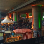 Zelte und Publikum unter einer Brücke beim Brückenfestival