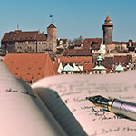 Ein Füller auf einem Notizblock mit der Nürnberger Kaiserburg im Hintergrund