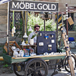 Ein Mann verkauft an einem mobilen Stand Kunsthandwerk