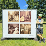 Ein Mann posiert neben einer Fotostellwand im Stadtpark