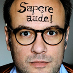 Portrait von René Sydow mit dem Schriftzug Sapere aude! auf der Stirn geschrieben.
