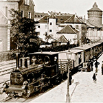 Historische Aufnahme einer alten Eisenbahn. Im Hintergrund ist einer der vier großen Nürnberger Stadtmauertürme zu sehen.