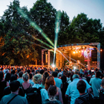 Eine große Menschenmenge steht vor einer Open Air Bühne