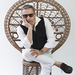 Rocko Schamoni sitzt auf einem Korbstuhl