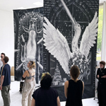 Besucherinnen und Besucher betrachten großformatige Gemälde, die in einer Ausstellungshalle von der Decke hängen