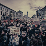 Dichte Menschenmenge bei einer Demonstration in München; viele halten Schilder mit Botschaften gegen Rechtsextremismus wie „Faschismus ist keine Meinung“ und „Deutschland ist bunt“ hoch.