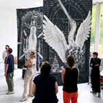 Großformatige, monochrome Banner mit surrealen Tierdarstellungen hängen in einem hellen Ausstellungsraum von der Decke, während eine Gruppe Menschen die Kunstwerke betrachten.