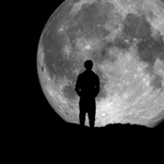 Silhouette einer stehenden Person vor großem Vollmond