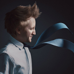 Junger Mann mit zerzaustem Haar trägt ein weißes Hemd und blaue Krawatte, die nach rechts weht.