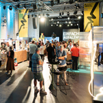 Menschen in einer großen, hell erleuchteten Halle mit Ausstellungsvitrinen
