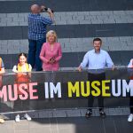Oberbürgermeister Marcus König (links) und 2. Bürgermeisterin Prof. Dr. Julia Lehner (rechts) hinter einem Banner zu Muse im Museum