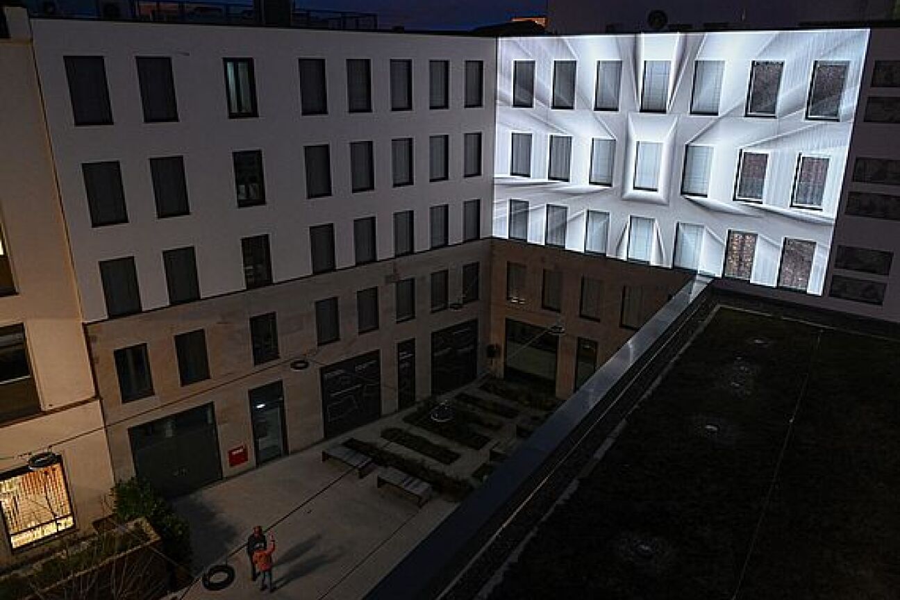 Arrival von MOATIK und Frieder Nagel, Bild © Berny Meyer / Stadt Nürnberg Von oben sieht man in einen Hof, die rechte Seite ist mit einer Projektion in weiß beleuchtet, Bild © Berny Meyer / Stadt Nürnberg