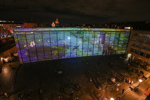 Blick von oben auf die Fassade des Neuen Museum mit einer Projektion von Philipp Geist, hinten die Oper