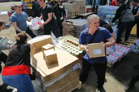 Helferinnen und Helfer packen eine Lebensmittellieferung in Charkiw aus