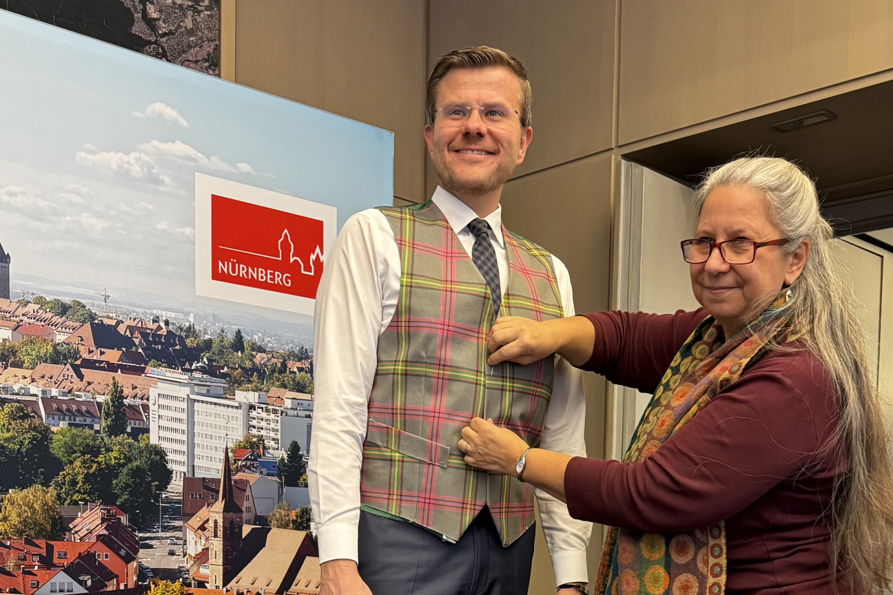 Oberbürgermeister Marcus König bei der Anprobe einer Weste mit dem Jubiläumstartan Nürnberg - Glasgow.