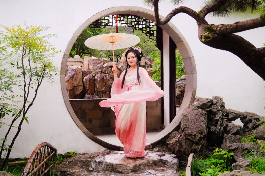 Eine traditionell gekleidete Frau im Garten des Meisters der Netze in Suzhou, China