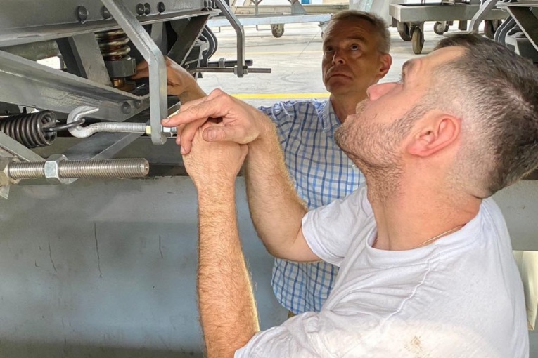 Ein polnischer und ein deutscher Ingenieur blicken nachdenklich auf die Drehgestelle des Zeppelinwagens.