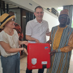 Stephanie Wimmer und Wolfgang Müller von der Stadt Nürnberg übergeben ein Ersatzteil in Sokodé, Togo
