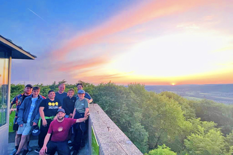 Bild © Andreas Stoiber / Stadt Nürnberg Gruppe von Teilnehmern stehen auf einem Aussichtsturm mit einem Sonnenaufgang im Hintergrund, Bild © Andreas Stoiber / Stadt Nürnberg