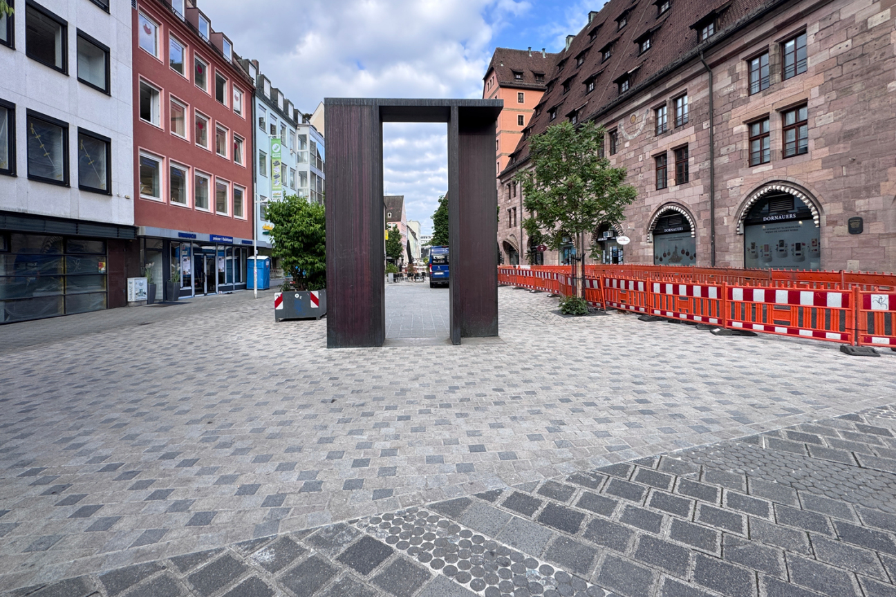 Die Neugestaltung der nördlichen Platzhälfte soll den Hallplatz mit neuem Granitbelag und zusätzlichen Aufenthaltsflächen weiter aufwerten. Aufgrund eines Lieferengpasses beim benötigten Granitpflaster müssen die Arbeiten auf der Baustelle vorübergehend pausieren. Alle Geschäfte können über sogenannte Grabrücken oder asphaltierte Flächen erreicht werden., Bild © André Winkel / Stadt Nürnberg