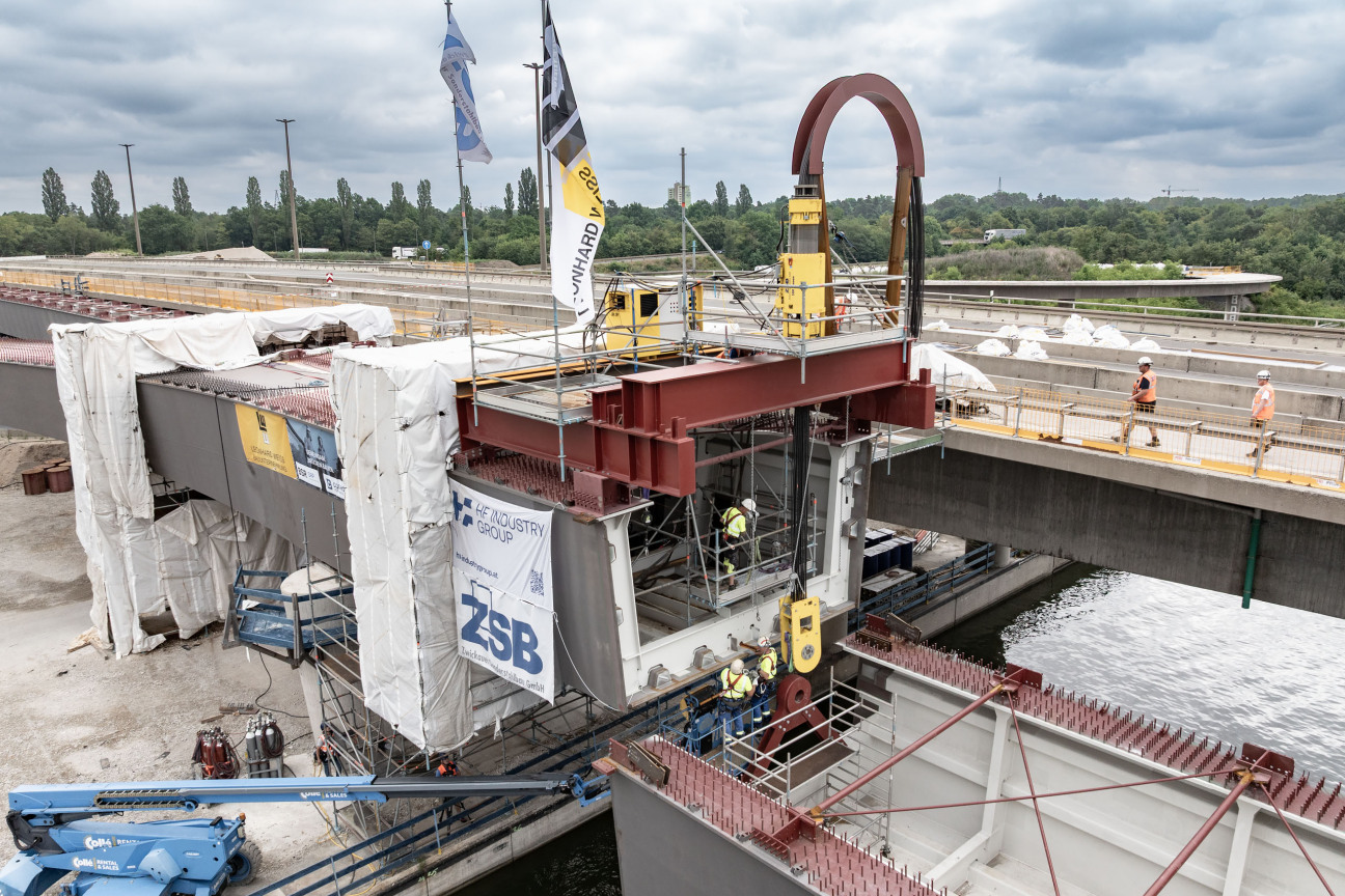 Lückenschluss über dem Main-Donau-Kanal: Am Dienstag, 30. Juni 2026, hat das Projekt Hafenbrücken eine weitere Hürde genommen. Mithilfe zweier Spezialhebegeräte wurde ein 75 Meter langes Brückenteil aus Stahl Millimeter für Millimeter in seine Position gebracht.