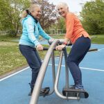Sportbegeisterte Damen an einem Gerät in einem Bewegungspark.